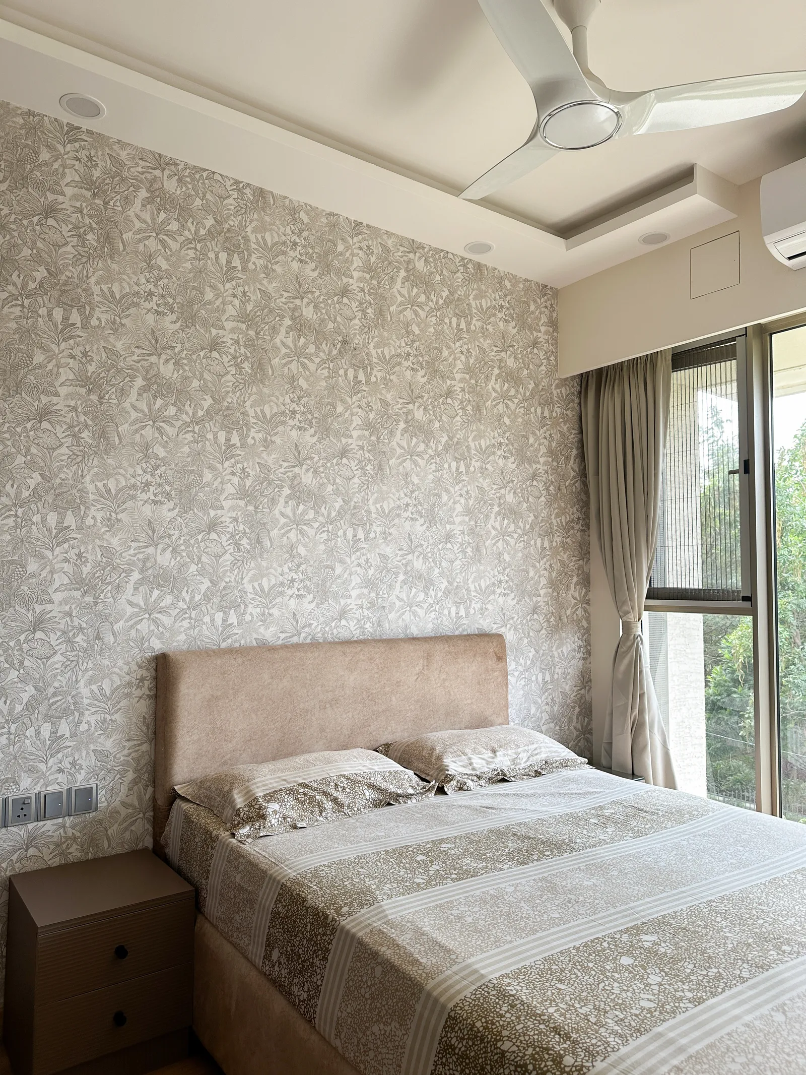 Guest bedroom with textured wallpaper and upholstered headboard — Somani's Residence